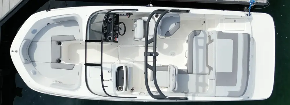 Top view of a white motorboat docked, with seating and control console visible.