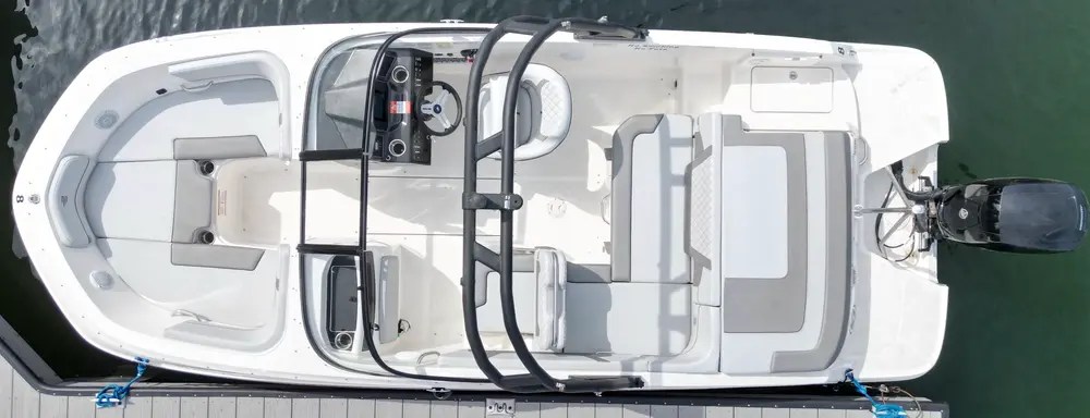 Top view of a small white motorboat docked at a pier.