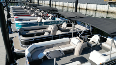Pontoon boats docked in a marina with black canopies.